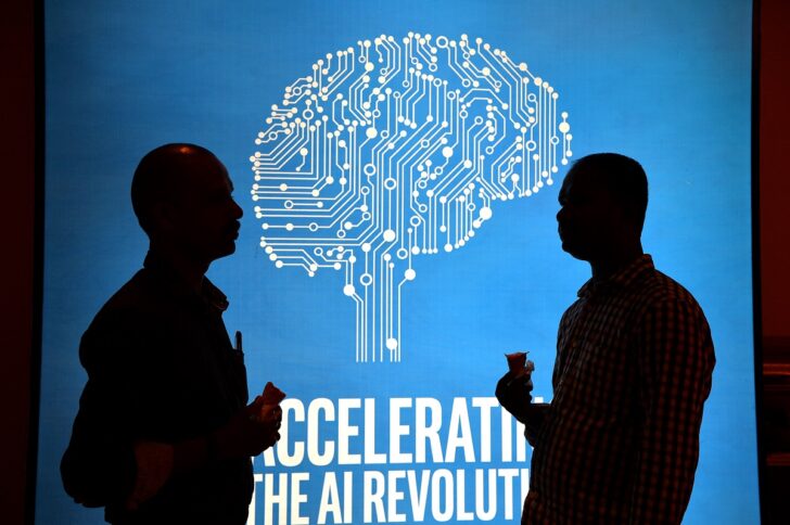 TECH-AI-INTEL ผู้ร่วมงานอินเทลเอไอ ในปี 2560 ที่ประเทศอินเดีย ยืนด้านหน้าโปสเตอร์จำลองภาพสมองกลดิจิทัล