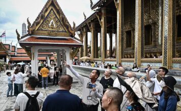 ภาพถ่ายมัคคุเทศก์กำลังบรรยายข้อมูลแก่นักท่องเที่ยว ภายในวัดพระศรีรัตนศาสดาราม (วัดพระแก้ว)