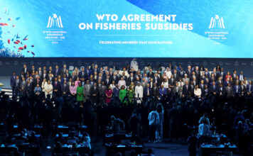 Delegates pose for a family photo during the 13th WTO ministerial conference in Abu Dhabi