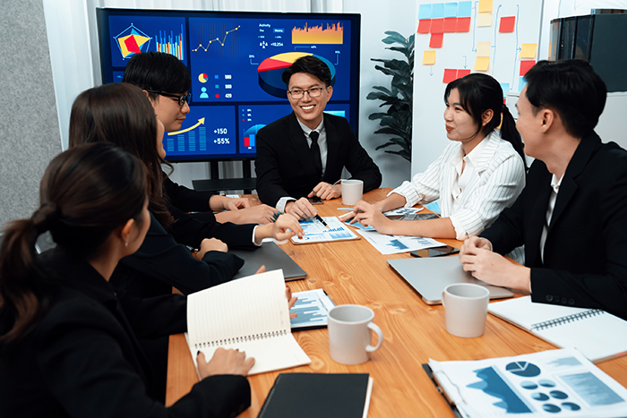 Business team of financial data analysis meeting report paper in harmony office.