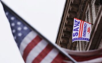 ธงแสดงข้อความ Save Democracy ภาพโดย REUTERS/Brian Snyder