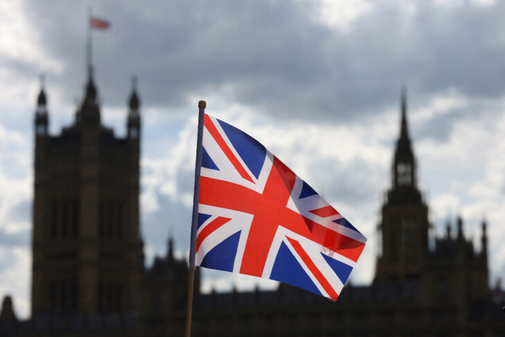 UK-Parliament อาคารรัฐสภาสหราชอาณาจักรอยู่เบื้องหลังธงธงสหราชอาณาจักร
