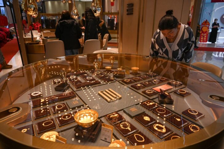 China Gold ลูกค้าที่กำลังเลือกดูทองคำรูปพรรณ ภาพโดย Jade Gao / AFP