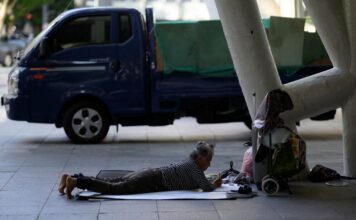 หญิงชราที่หน้าสถานีรถไฟปูซาน (ภาพโดย ANTHONY WALLACE / AFP)