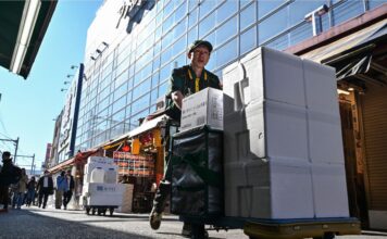 พนักงานส่งของที่ตลาดอเมโยโกะ อุเอโนะ โตเกียว ภาพโดย Richard A. Brooks / AFP