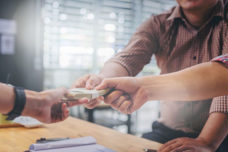 business-partners-meeting-passing-money-new-business-project-table 7 แบงก์รัฐ จัดแคมเปญทั้งแจก-ลด มอบของขวัญปีใหม่ 2568 ให้ประชาชน