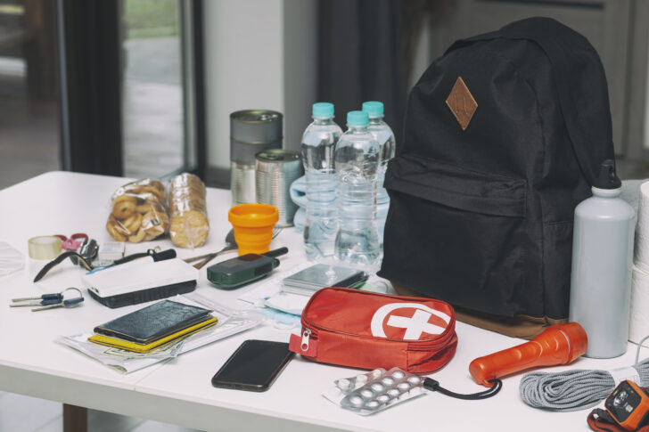 Emergency backpack equipment organized on the table. Documents,
