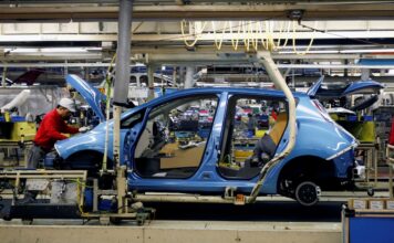 FILE PHOTO: An employee of Nissan Motor works on its Leaf electric car on an assembly line at Oppama plant, in Yokosuka