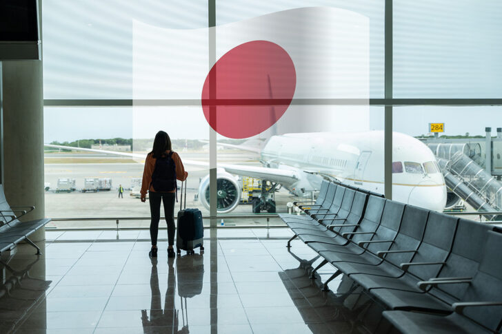 woman-with-suitcase-hand-looks-out-airport-window-while-waiting-her-flight เปิดรับ 'สาวไทย' อายุไม่เกิน 30 ปี ไม่มีรอยสัก-สูงเกิน 150 ซม. ฝึกงานที่ญี่ปุ่นเงินเดือนดี