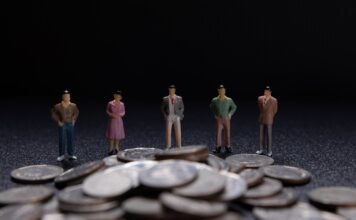 Miniature people: Group of small businessmen standing on coin with Business Growth concept.