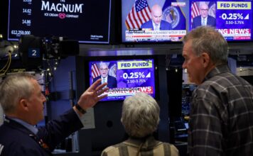 ‘เฟด’ หั่นดอกเบี้ยรอบ 3 อีก 0.25% ‘เซอร์ไพรส์’ กลับมาซื้อพันธบัตร A screen displays the Fed rate announcement as traders work on the floor of the NYSE in New York