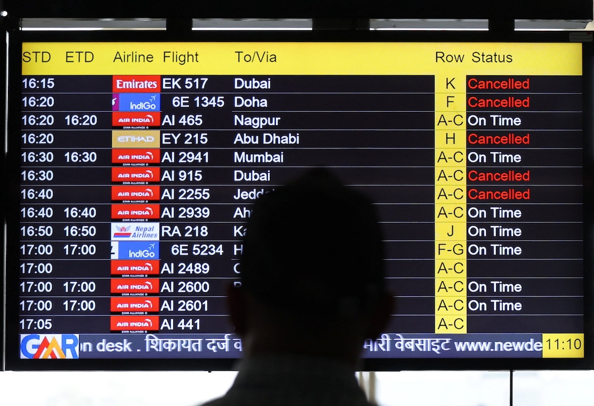 A man views a screen displaying flight information at the Indira Gandhi International airport in New Delhi