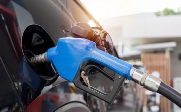 วิกฤตพลังงาน ตระหนัก แต่อย่าตระหนก Fuel nozzle pumping gasoline into car tank at gas station, close up view showing energy and transportation