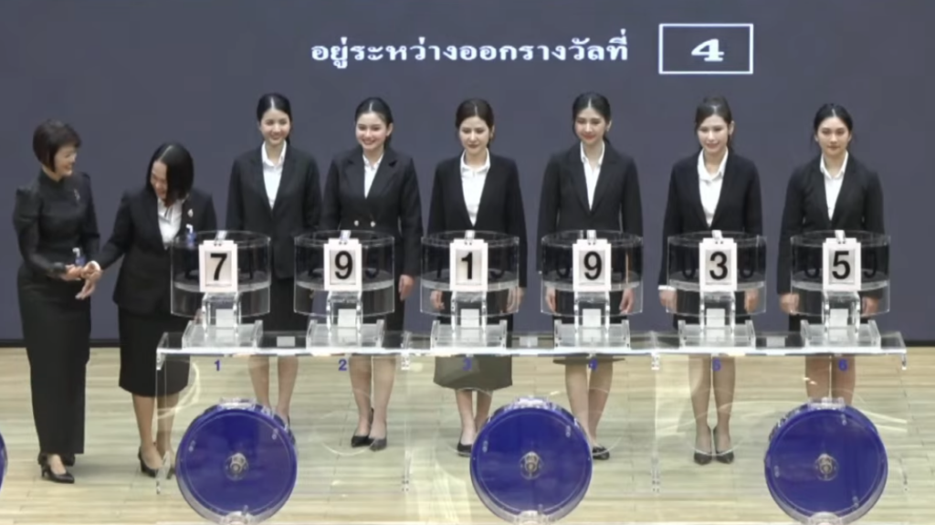 ประธานลใช้ฆ้อนยางเคาะอุปกรณ์ออกรางวัล หลังตัวเลขแสดงไม่ตรงช่อง